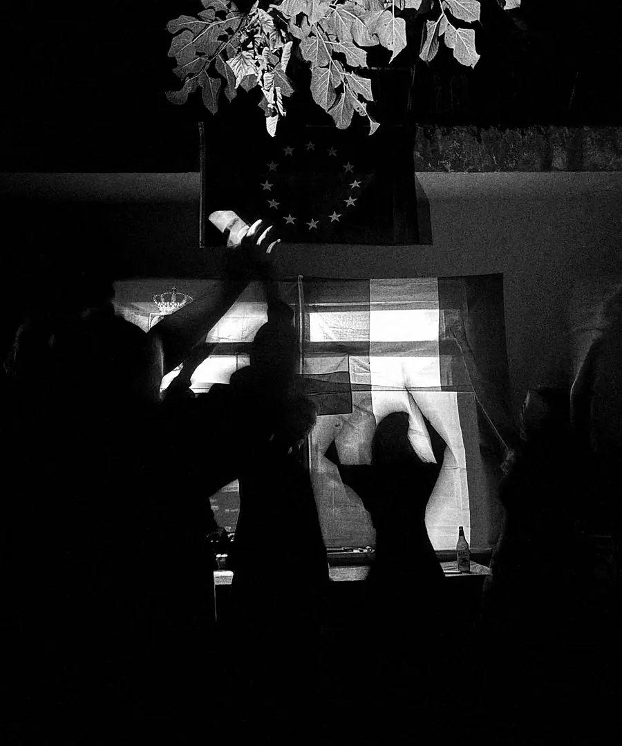 Black-and-white photograph from a previous exchange: silhouettes of young people waving in front of projected national flags.