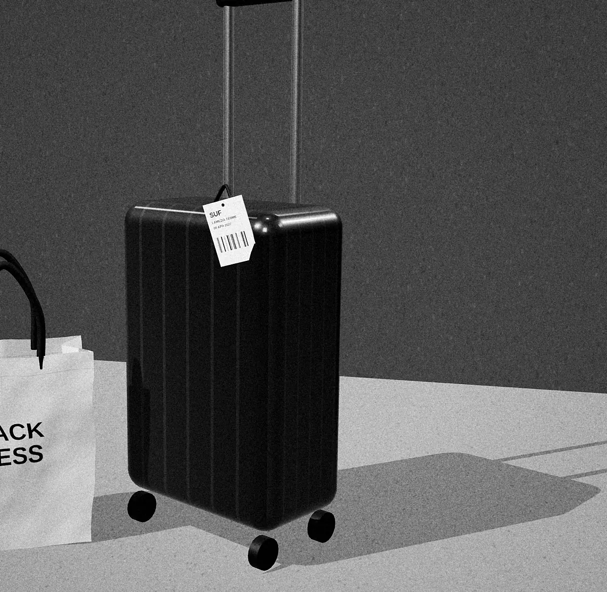 Black-and-white photograph of a hard-shell suitcase with a luggage tag reading SUF Lamezia Terme, next to a small paper bag printed PACK LESS.